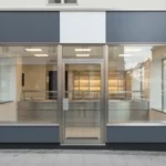 Moderne Ladenfront mit großen Glasfenstern und zentraler Tür.