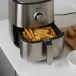 Edelstahl-Heißluftfritteuse mit Pommes im Korb.