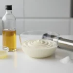 Ölflasche, Schüssel mit geschlagener Sahne, Stabmixer.